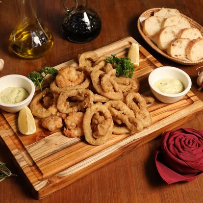 Fritto misto — calamari and shrimp on wooden board at Bellini