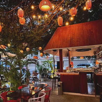 Bellini bar at night with orange lanterns and lush tropical trees