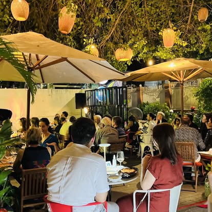 Bellini garden at night with umbrellas and guests dining