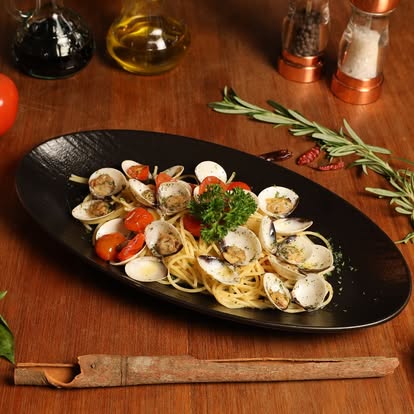 Spaghetti Vongole on black oval plate at Bellini